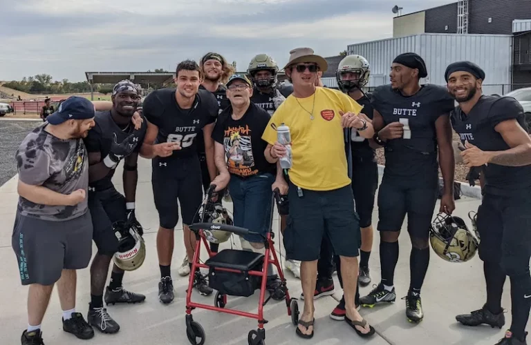 a group photo of Butte College football players posing with several adults with disabilities